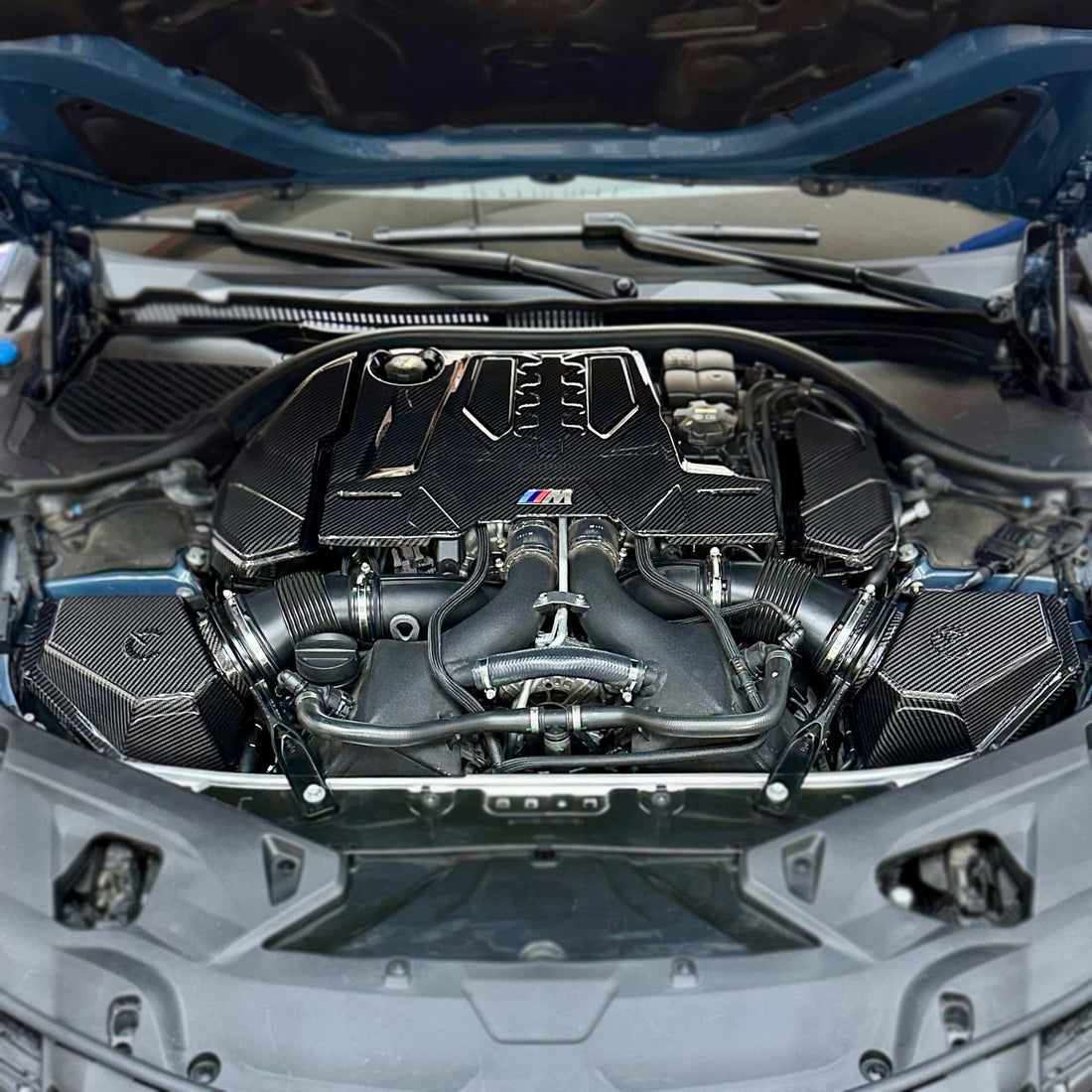 CarBahn San Jose technician installing carbon fiber cold air intake system on European turbocharged car.