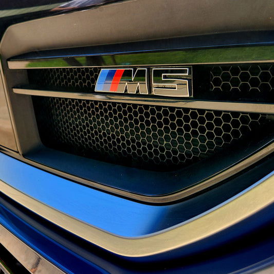 BMW G90 M5 sedan in motion on open road, showcasing high-performance tuning potential with CarBahn Stage 1 Controller upgrade for enhanced power and throttle response